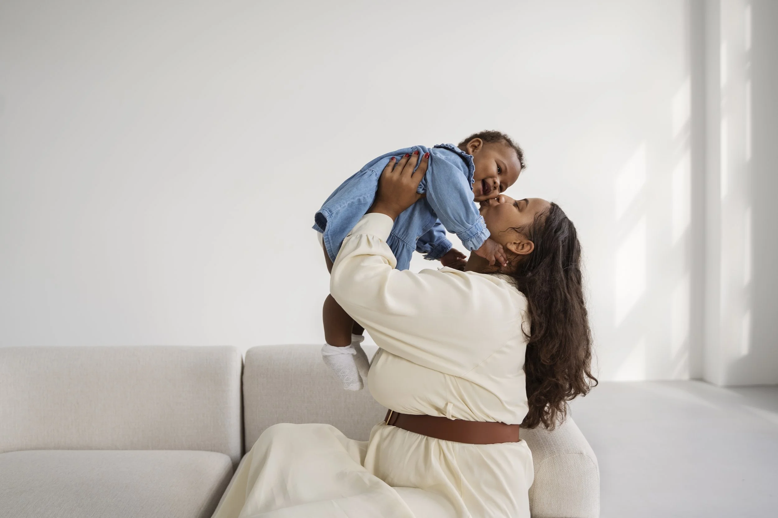 Mother lifting her smiling child at home
